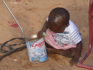 nina con lata de leche orfanato Burkina