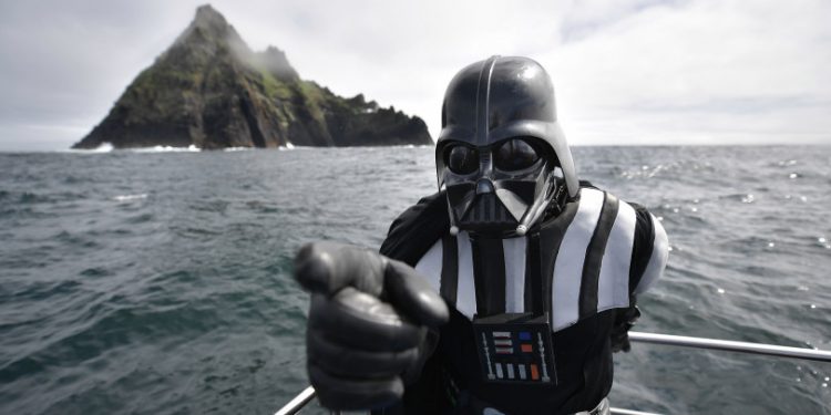 PORTMAGEE, IRELAND - MAY 04: A Star Wars fan dressed as the character Darth Vader takes a boat trip to the Skelligs on International Star Wars day May 4, 2018 in Portmagee, Ireland. The first ever Star Wars festival is taking place against the backdrop of the famous Skellig Michael island which was used extensively in Episode VII and Episode VIII of the popular science fiction saga. The small fishing village of Portmagee, which is closest to the location, has seen a boom in tourism following the latest films. The vilage will host a Star Wars drive-in and a Star Wars themed Irish dancing competition over the weekend. Today is known as 'May the fourth be with you' day. (Photo by Charles McQuillan/Getty Images)