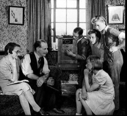 Familia en el salón de casa reunida en torno a la radio / Ahora me ves
